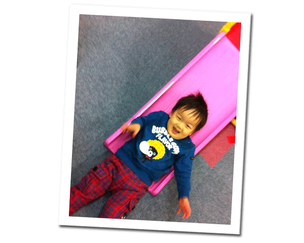 マットの上で全身を使って遊ぶ子供